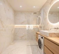 Bathroom in a 4-room apartment with a large shower, washing machine, and backlit mirror.