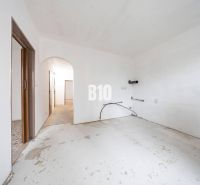 Unfurnished room in a 4-room apartment with white walls and a concrete floor.