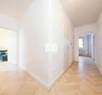 A hallway in a 4-room apartment with a wooden decor floor and light-colored walls.