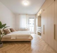 Bedroom in a 4-room apartment with a large wardrobe and a wooden decor floor.
