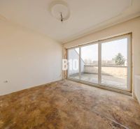 Empty room with large windows and flooring in a family house.