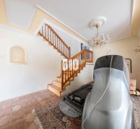Interior of a family house with a staircase, chandelier, flooring, and sports equipment.