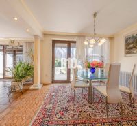 A dining table in a family house with carpets and flowers on the table.