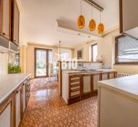 A kitchen in a family house with a dining area, windows, and access to the garden.
