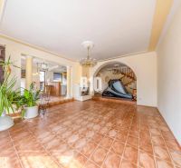 Interior of a family house with ceramic flooring, a staircase, and houseplants.