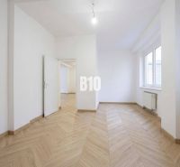 A room with white walls and a wooden decor floor in a 3-room apartment.