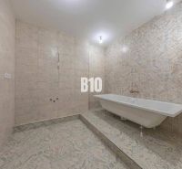 A bathroom in a 3-room apartment with a bathtub and decorative tiles.