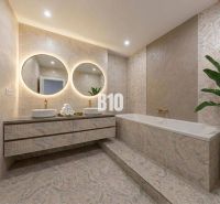 Elegant bathroom with a bathtub, double sink, and large mirrors in a 3-room apartment.