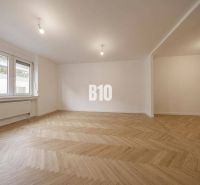 A spacious room with a wooden decor floor in a 3-room apartment.