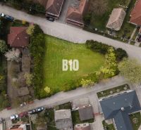 Aerial view of a residential plot in Kráľovičove Kračany surrounded by greenery and houses.