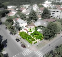 A family house in the Bratislava - Staré Mesto area, surrounded by greenery and a road with cars.