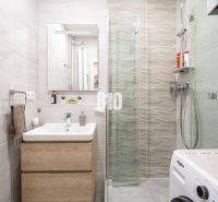 Bathroom in a 2-room apartment with a washing machine, sink, and shower.