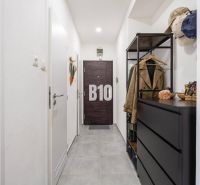 A hallway with dark furniture in a 2-room apartment with a tiled floor.