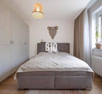 A bedroom with a comfortable bed, built-in wardrobes, and a window in a 2-room apartment.