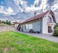 A family house in Marianka, with a terrace and lawn, surrounded by a stone wall.