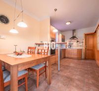 A kitchen in a family house with wooden furniture and ceramic tiles.