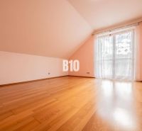 A spacious room with a wooden floor and a French window in a family house.