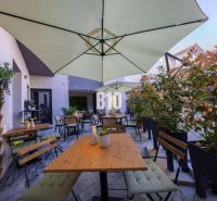 Outdoor gastro spaces in Bratislava - Old Town with wooden furniture and greenery.