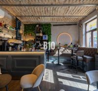 A stylish café with a wooden decor floor and cozy seating in the gastro area.