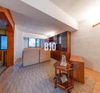 Living room in a family house with a perspective of wooden furniture and comfortable seating sets.