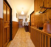 A hallway in a family house with wooden paneling and clay pots for decoration.