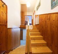 Wooden staircase and wall cladding in a family house with a floor featuring a wood decor.