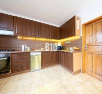 A kitchen with wooden cabinets, a floor with a wooden decor in a family house.