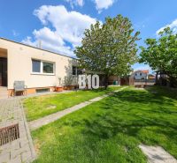 The exterior of a family house in Kalinkovo with a lawn, trees, and a terrace.