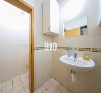 Bathroom with a sink and mirror, white tiles. Commercial spaces.