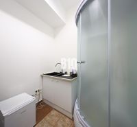 Shower corner and kitchen sink in commercial premises with a white interior.