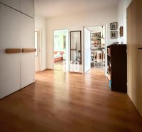 The hallway of a 3-room apartment with a wooden decor floor and built-in wardrobes.