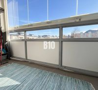The balcony of a 3-room apartment in Ružomberok with a view of the city and mountains.