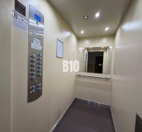 The interior of the elevator in the building, mirror and lighting, materials used in light tones.