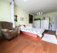 A bright room in a 3-room apartment with a wooden decor floor and bedroom furniture.