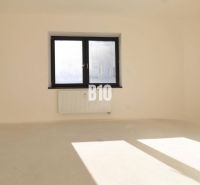 An empty office with two windows and a radiator, light walls, floor without wood decor.
