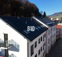 Office buildings on Matúškova Street in Dolný Kubín surrounded by mountain scenery.