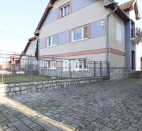 A family house in Turany with a stone fence and a paved courtyard.