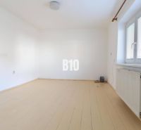 An empty room with a wood-patterned floor in a family house.