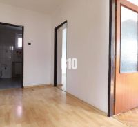 A hallway in a family house with a wooden decor floor and white walls.