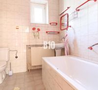 Bathroom in a family house with white tiles and red accessories.