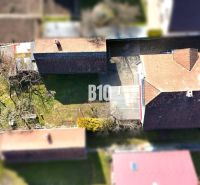 Aerial view of a family house in Turany with a yard and a greenhouse.