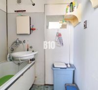 A bathroom with a shower curtain and a sink in a 3-room apartment.