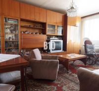 A living room in a 3-room apartment with retro furniture, a carpet, and flowers on the table.