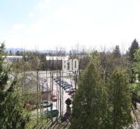 A view from a 3-room apartment in Martin, overlooking greenery and a parking lot.
