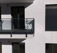 A balcony with glass railings and shutters on a two-room apartment building in Dolný Kubín.