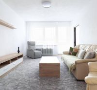 Living room in a 3-room apartment with a comfortable sofa and leather armchairs.