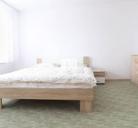 A bedroom in a 3-room apartment with a double bed, white furniture, and a carpet.