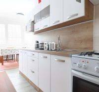 A kitchen in a 3-room apartment with a gas stove and a floor with a wood decor.