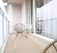 Balcony of a 1-room apartment with two chairs and sliding doors.