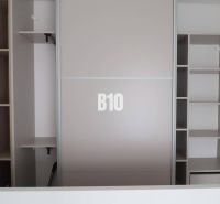 A built-in wardrobe in a studio apartment with open shelves and hanging space.